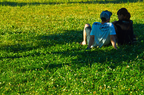 草むらに座り込むカップル