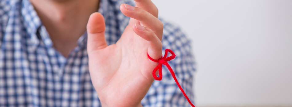 小指に赤い糸が結ばれている男性