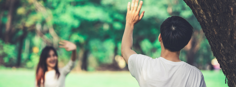 自然が多い場所で待ち合わせをする男女