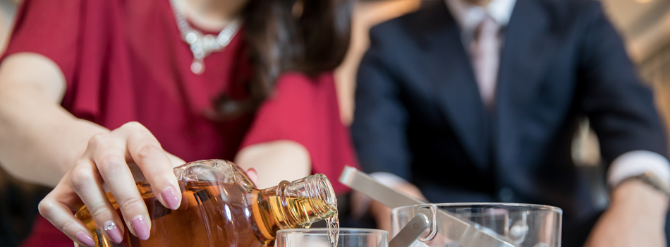 グラスにお酒を注ぐ女性