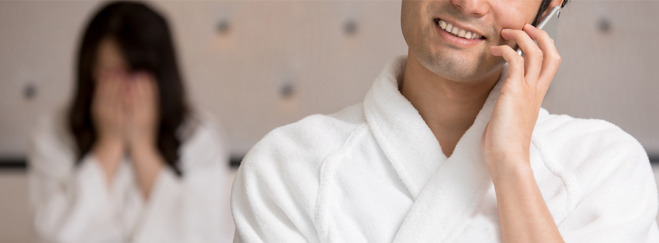 泣いている女性と、楽しげに電話する男性