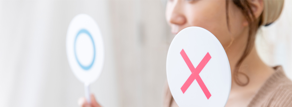 〇か×か判定している女性