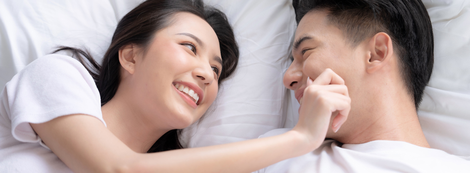 ベッドの上でふざけ合う男女