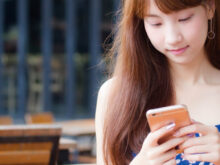 座ってスマートフォンをいじる女性