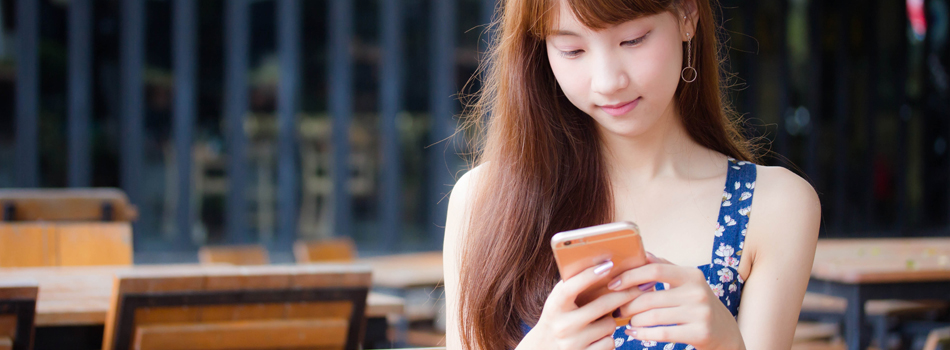 座ってスマートフォンをいじる女性