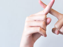 指を交差してバツマークを作っている