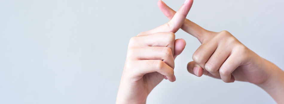 指を交差してバツマークを作っている