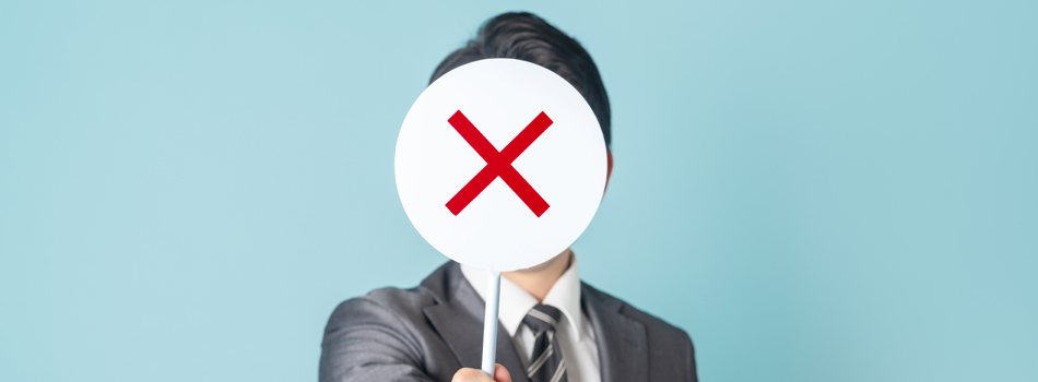 ×マークを持ったスーツの男性