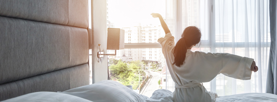 朝起きて身体を伸ばす一人の女性
