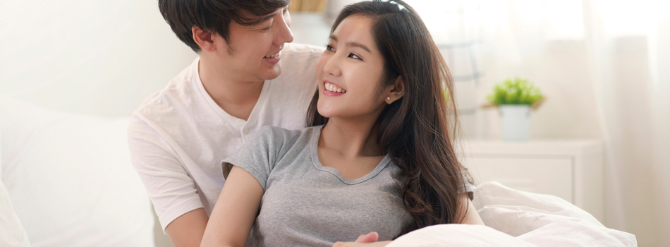 ベッドの上でじゃれあうカップル