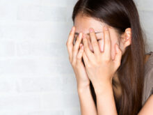 顔を覆い、ショックを受けている女性