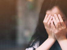 顔を手で覆う女性