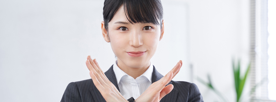 手で×マークを作る女性