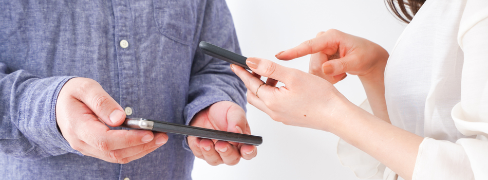 スマートフォンで連絡先を交換する男女