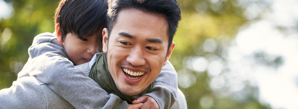 子供をおんぶして、幸せそうな男性