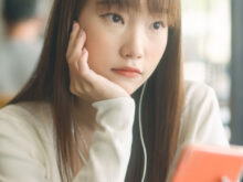 元気が無さそうにスマホを持っている女性