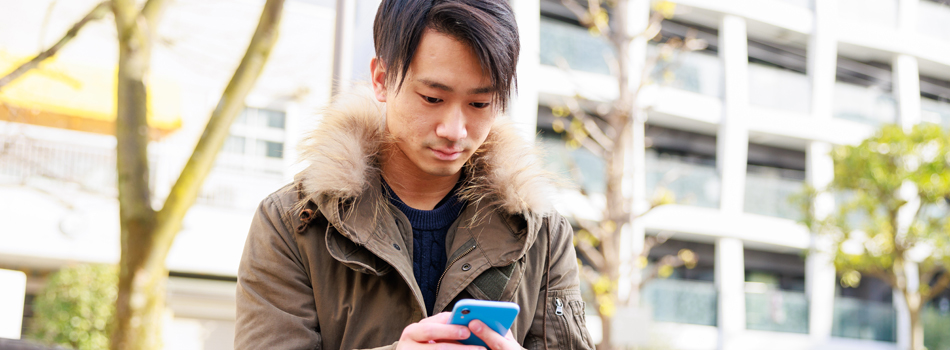外出してスマホを操作している男性