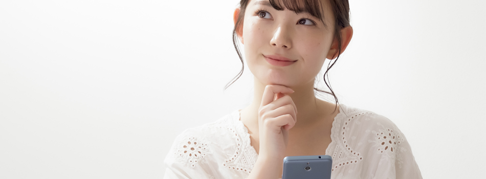 スマートフォンを持ち、何か考えている女性