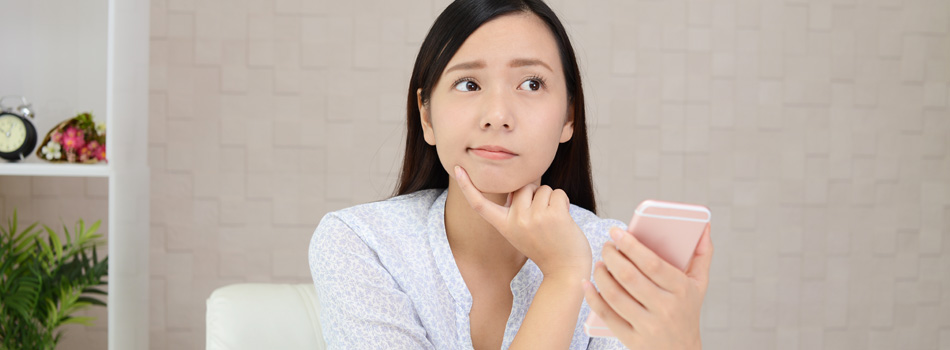 スマホを見て何か悩んでいる女性