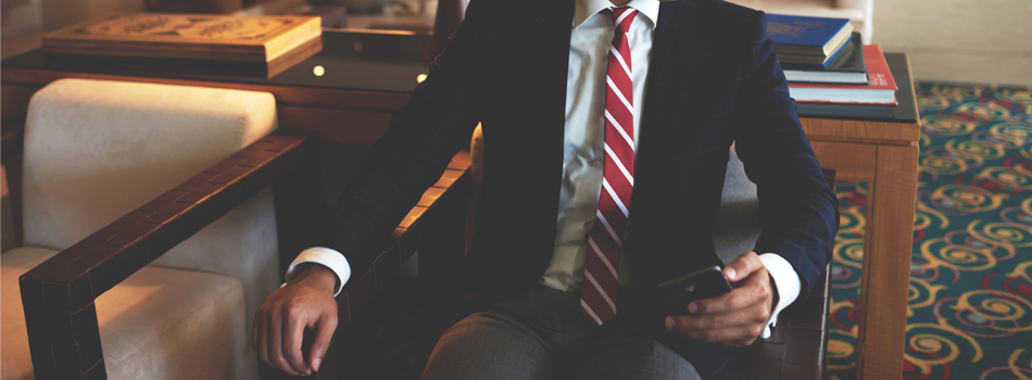 高級ホテルのロビーで座っているスーツの男性