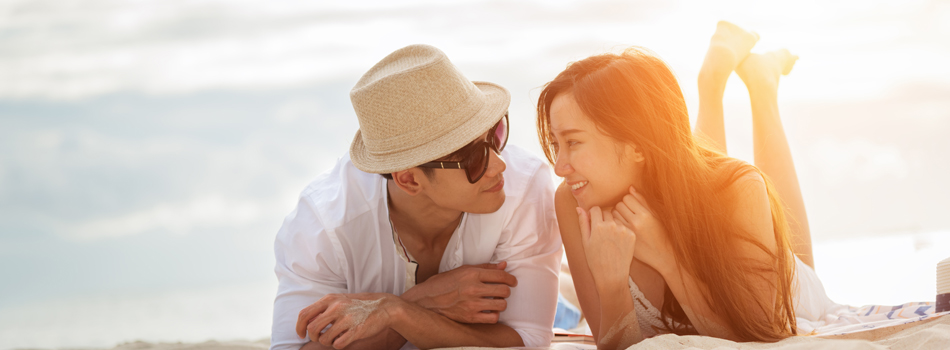 ビーチに寝そべって語り合うカップル