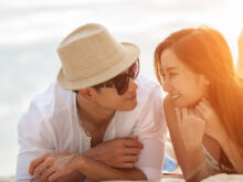 ビーチに寝そべって、語り合うカップル