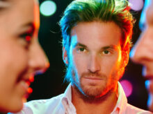 親密そうに話す男女を横から観察している男性