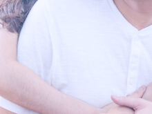 背後から男性を抱き締める女性