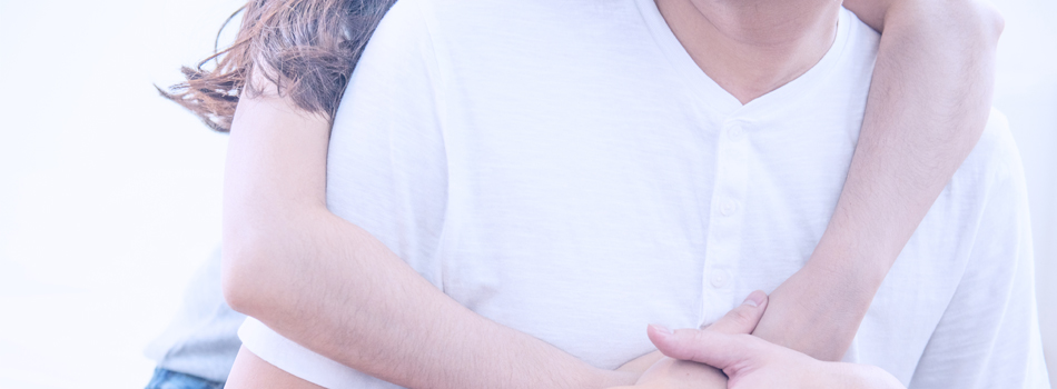 背後から男性を抱き締める女性