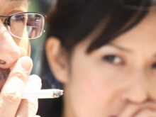 タバコを吸う男性と、怪訝な顔をする女性