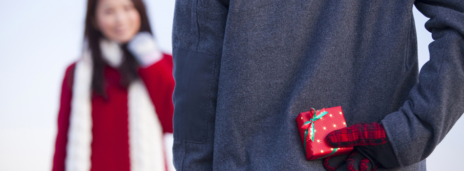 女性にサプライズでプレゼントを渡そうとしている男性