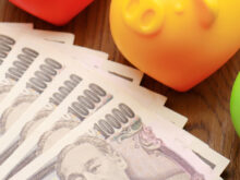 1万円札と貯金箱