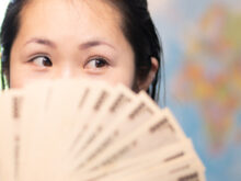 札束で顔を隠す女性