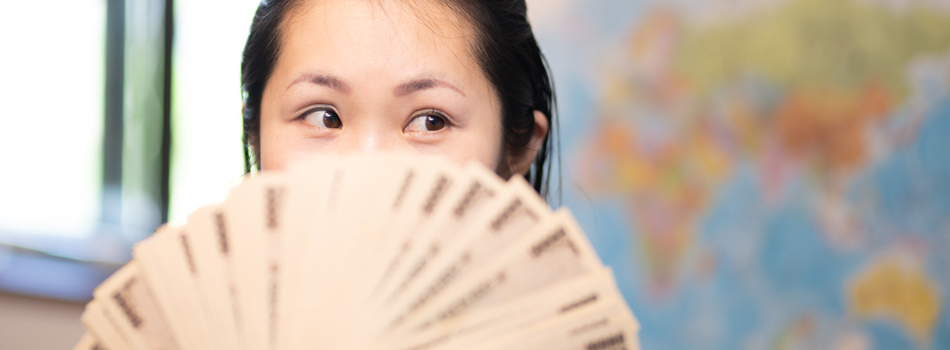 札束で顔を隠す女性