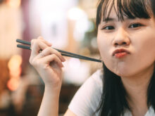 こちらを見ながら料理を食べている女性