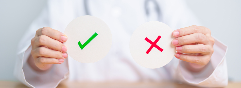 チェックマークと、×マークの札を持ったお医者さん