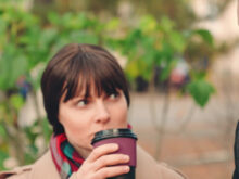 笑顔の初老男性と、男性をコーヒーを飲みながら見つめている女性