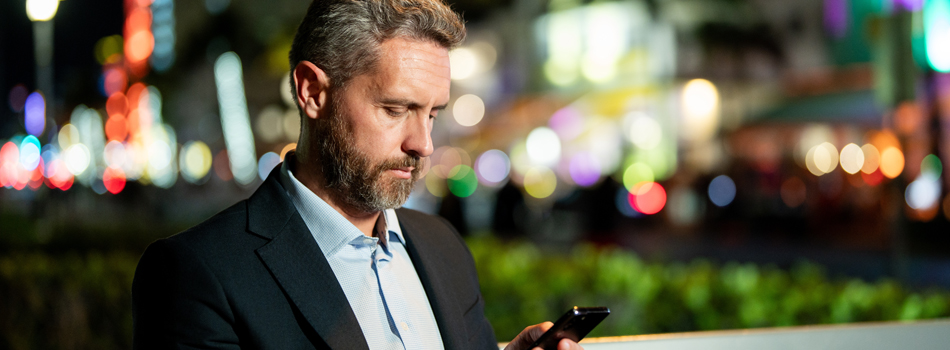 外でスマートフォンを見ているカッコイイ男性