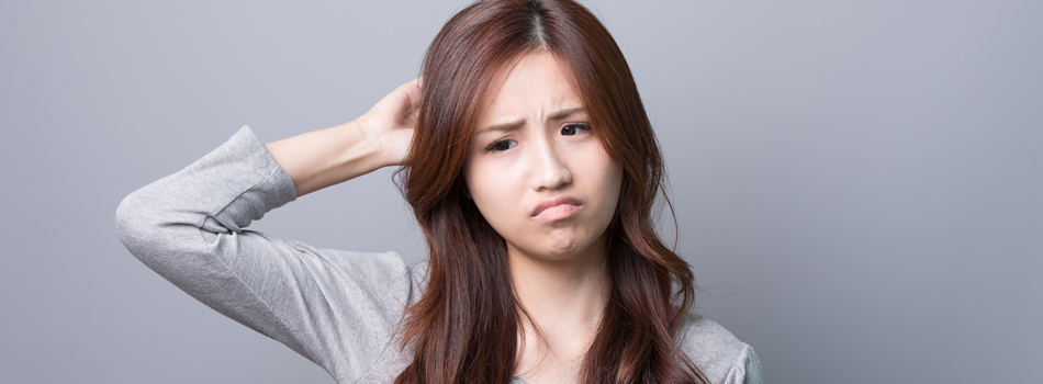 困り顔で頭をかく女性