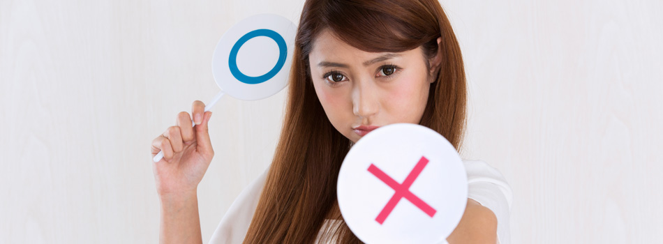 ×マークの札を向けてくる女性