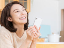 幸せそうにスマートフォンを持つ女性