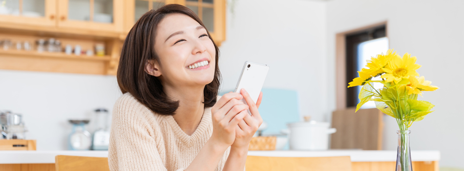 幸せそうにスマートフォンを持つ女性