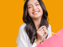 ショッパーを持って笑顔の女性