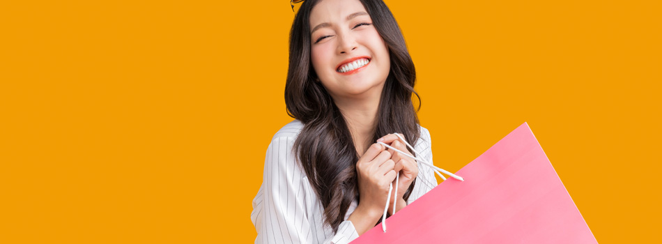 ショッパーを持って笑顔の女性