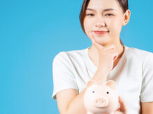 豚の貯金箱を持った女性