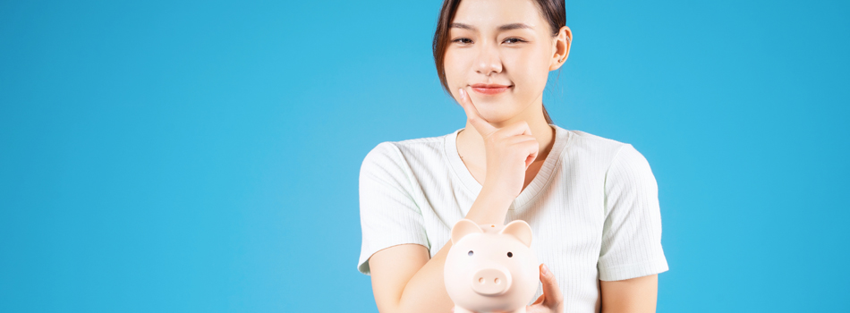 豚の貯金箱を持った女性