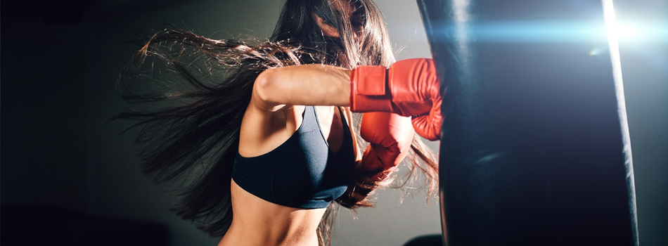 サンドバッグを殴り、運動している女性