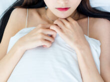 ベッドで仰向けになっている女性