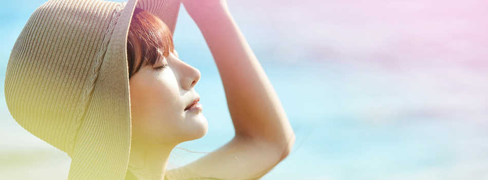 空を見上げ太陽光を浴びている女性