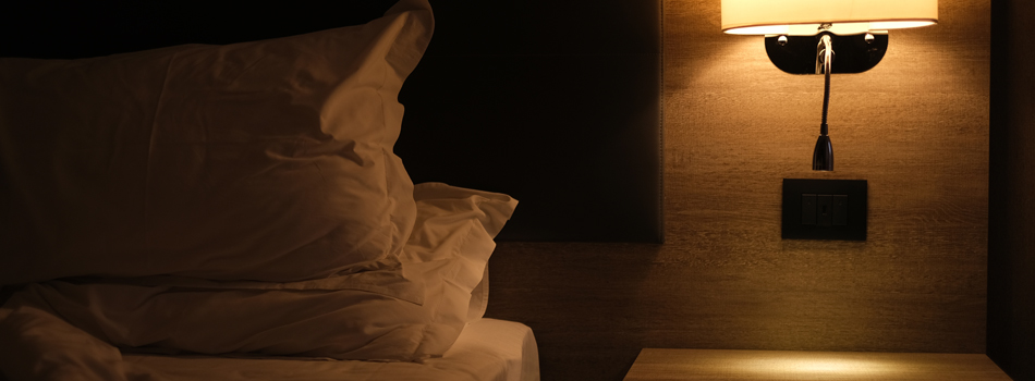 照明を暗くした部屋のベッド